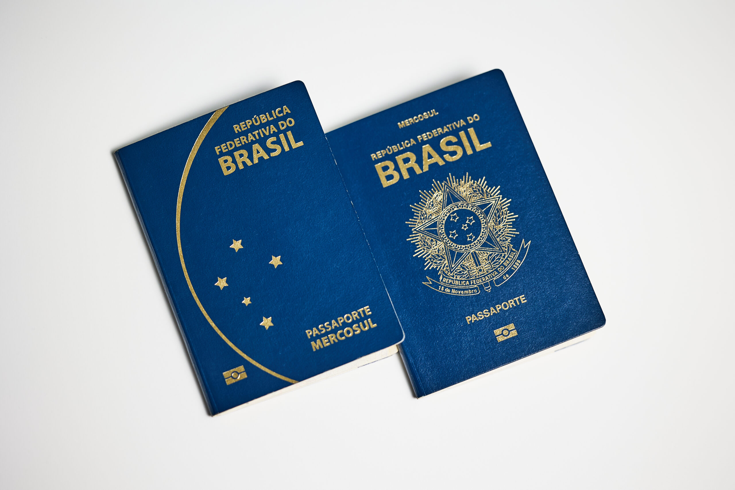 Two Brazilian passports in different design on white background.